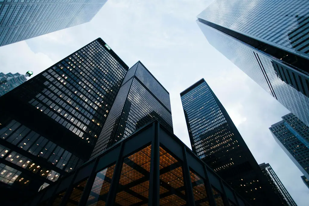 Glass office towers photographed from street level looking up toward the sky