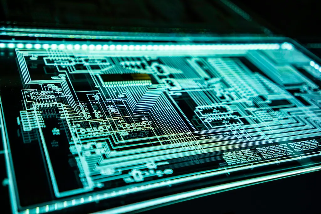 An illuminated circuit board pattern glowing blue in a dark environment